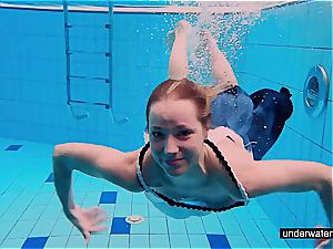 ginger-haired honey swimming bare in the pool